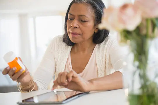 Mixed race woman researching medication on tablet computer Mixed race woman researching medication on tablet computer